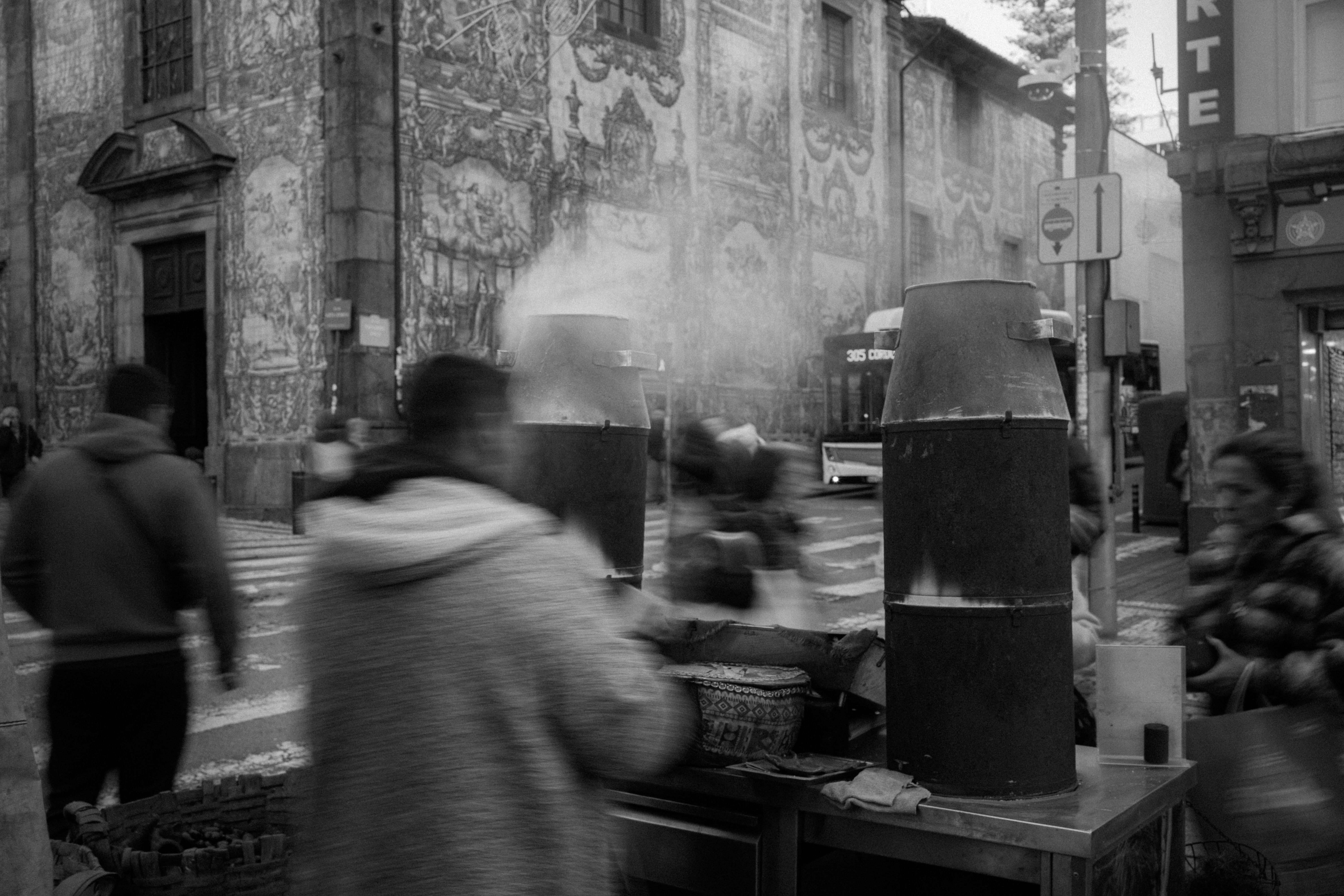 Blurred motion of people around a busy street food stand in an urban setting.