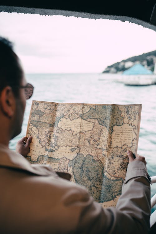 Man Holding a Map on a Boat 