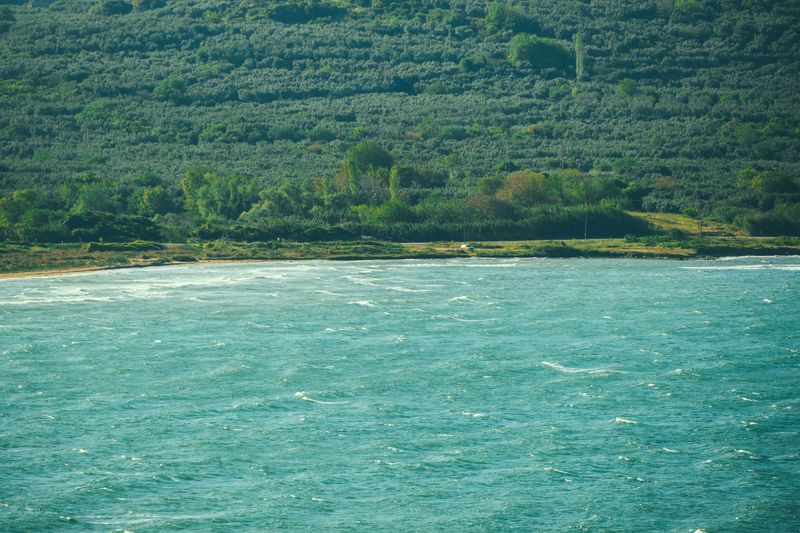 Green hills meeting a turquoise bay — Enes Beydilli on Pexels