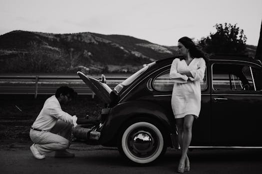 A couple with a vintage Volkswagen on a scenic road in Çanakkale, Türkiye.