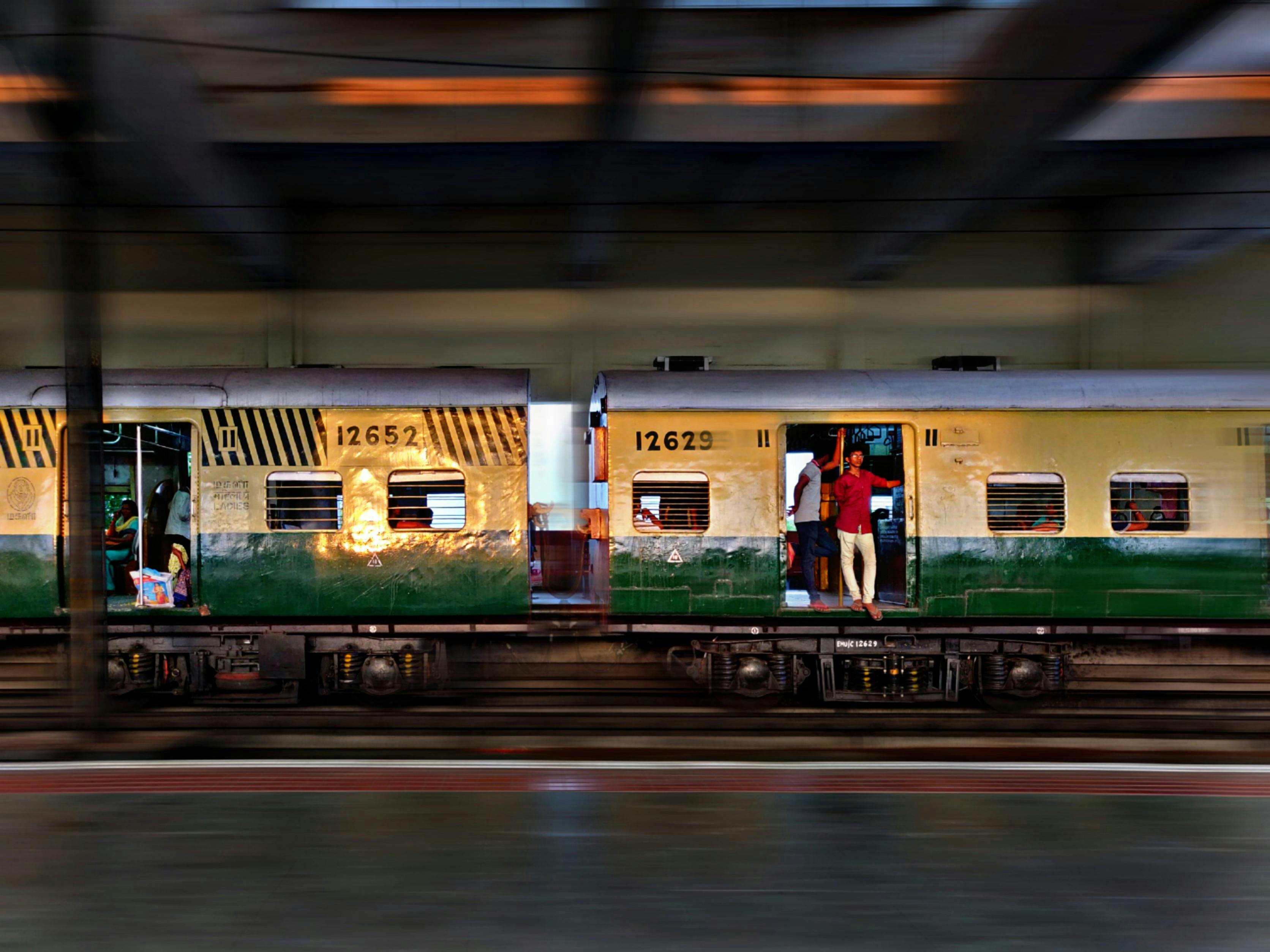 man wearing red shirt standing by the door of a train