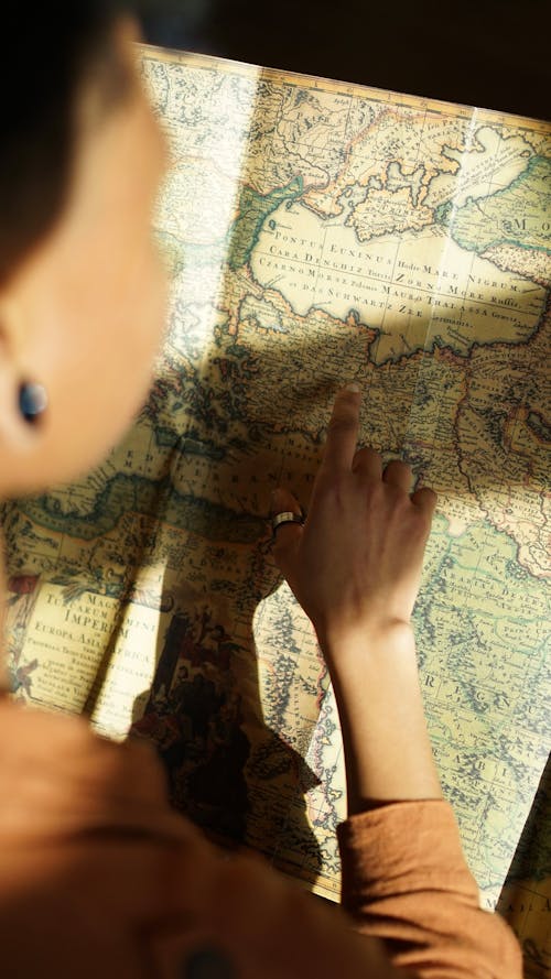 A woman is looking at a map with her hand