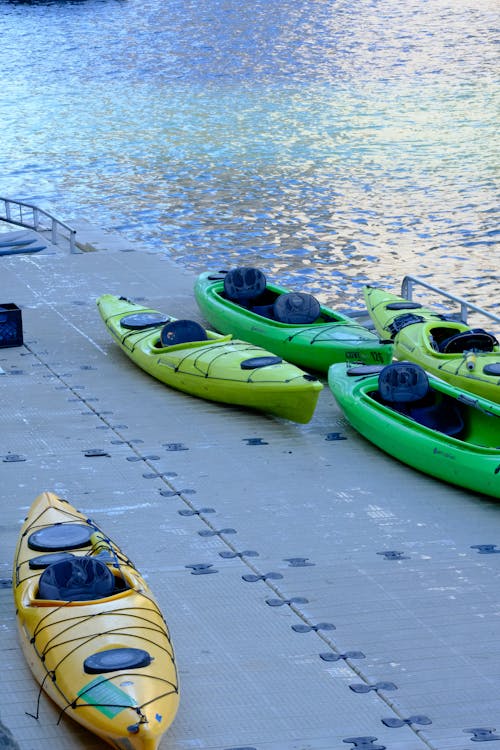A group of kayaks sitting on a dock next to a body of water