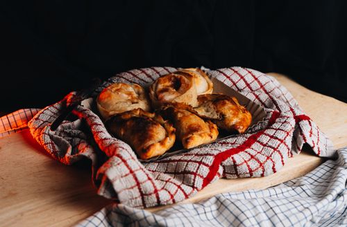 Free A close-up of freshly baked Argentine empanadas displayed on a checkered cloth. Stock Photo