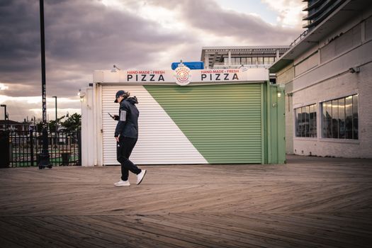 Woman in Jacket Walking with Smartphone