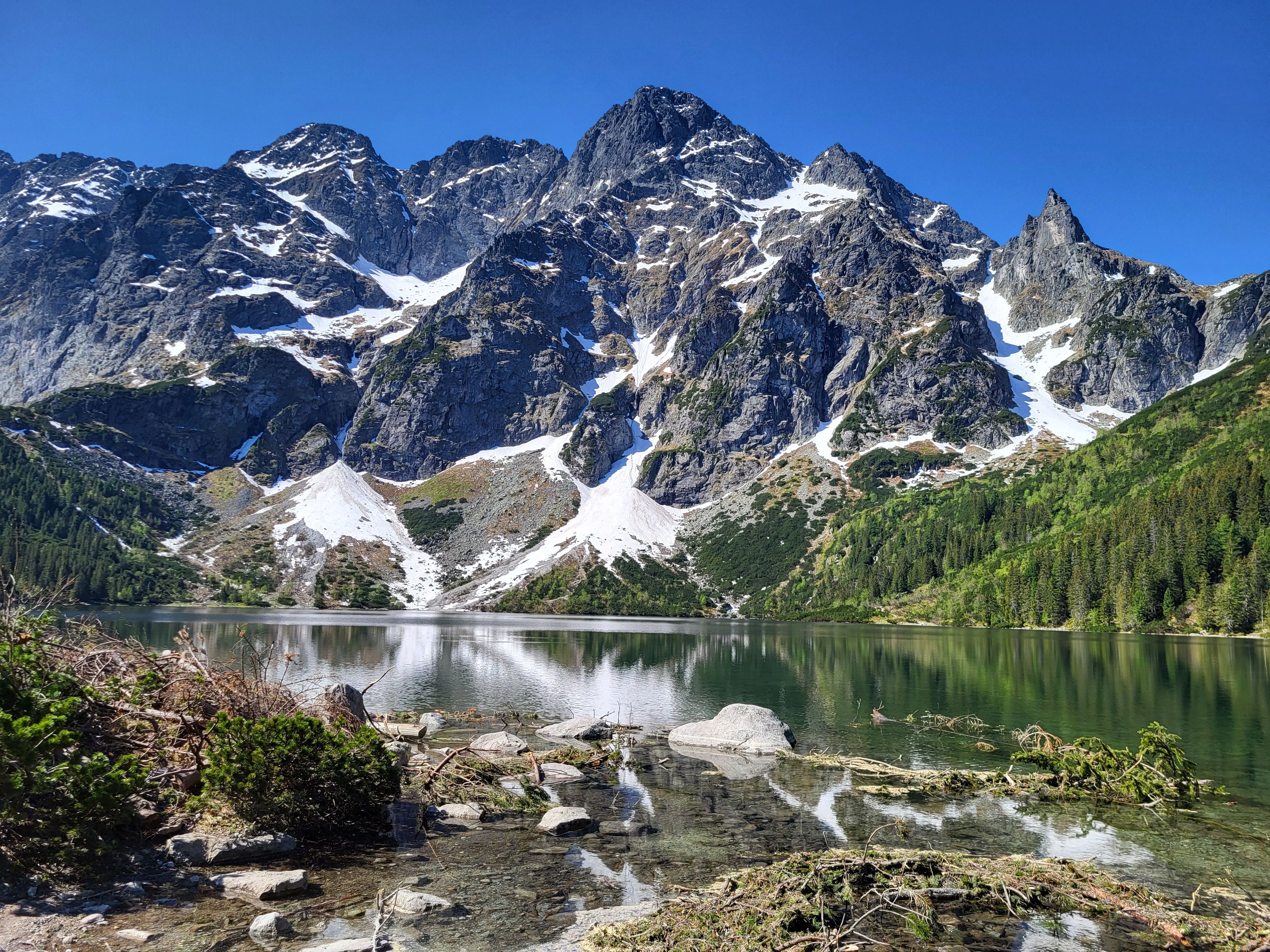 A mountain lake surrounded by snow capped mountains · Free Stock Photo