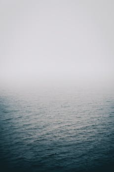 薄雾笼罩的湖泊景色宁静，蓝色的海水也十分平静，非常适合放松