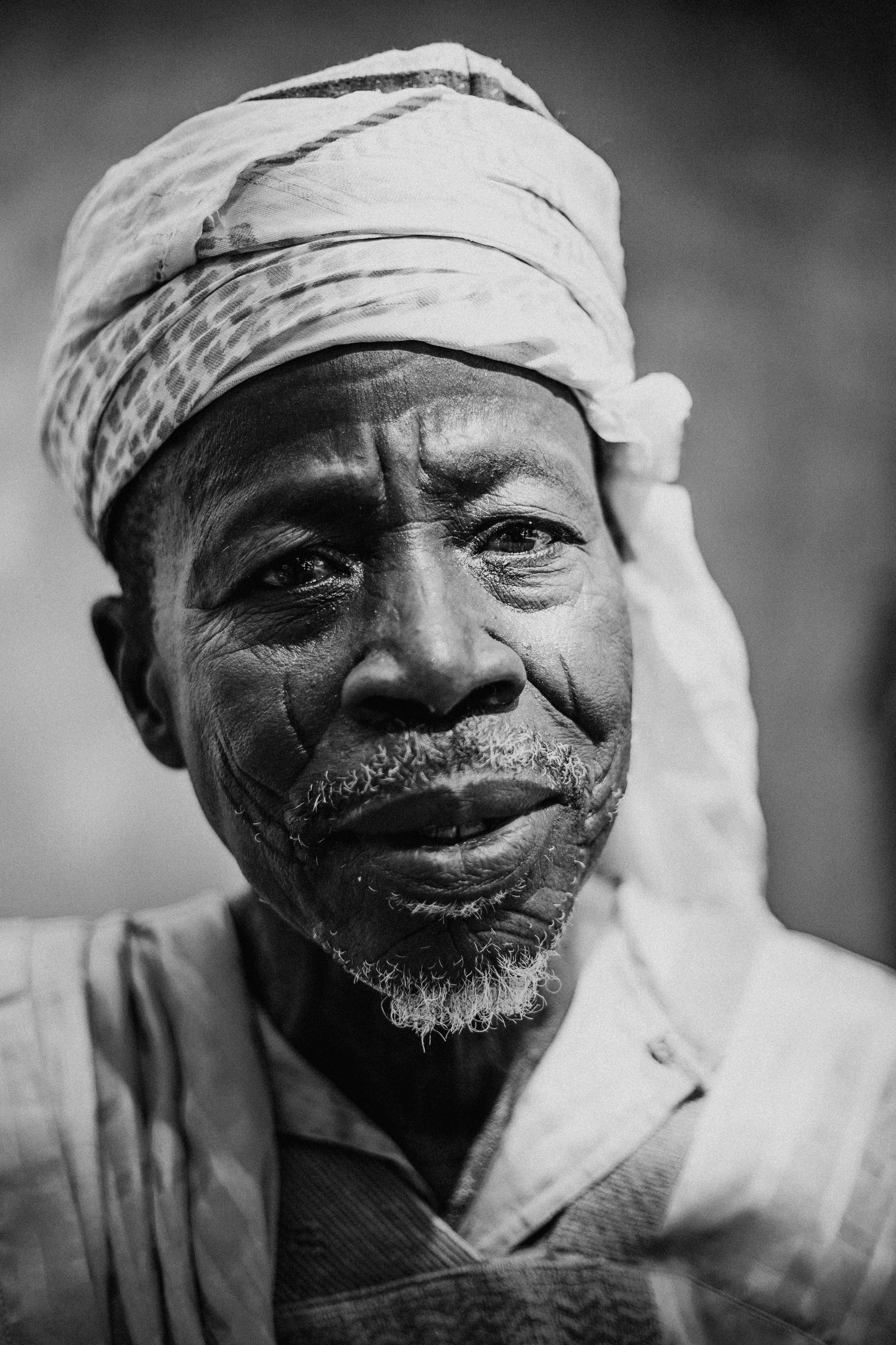 Black and white close-up portrait of an elderly man wearing a turban, conveying wisdom and experience.