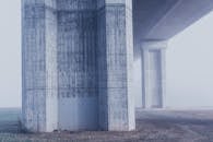 城市雾蒙蒙的环境中，混凝土桥柱呈现出朦胧的景象