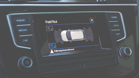 Close-up view of a car dashboard featuring a ParkPilot parking assist display.