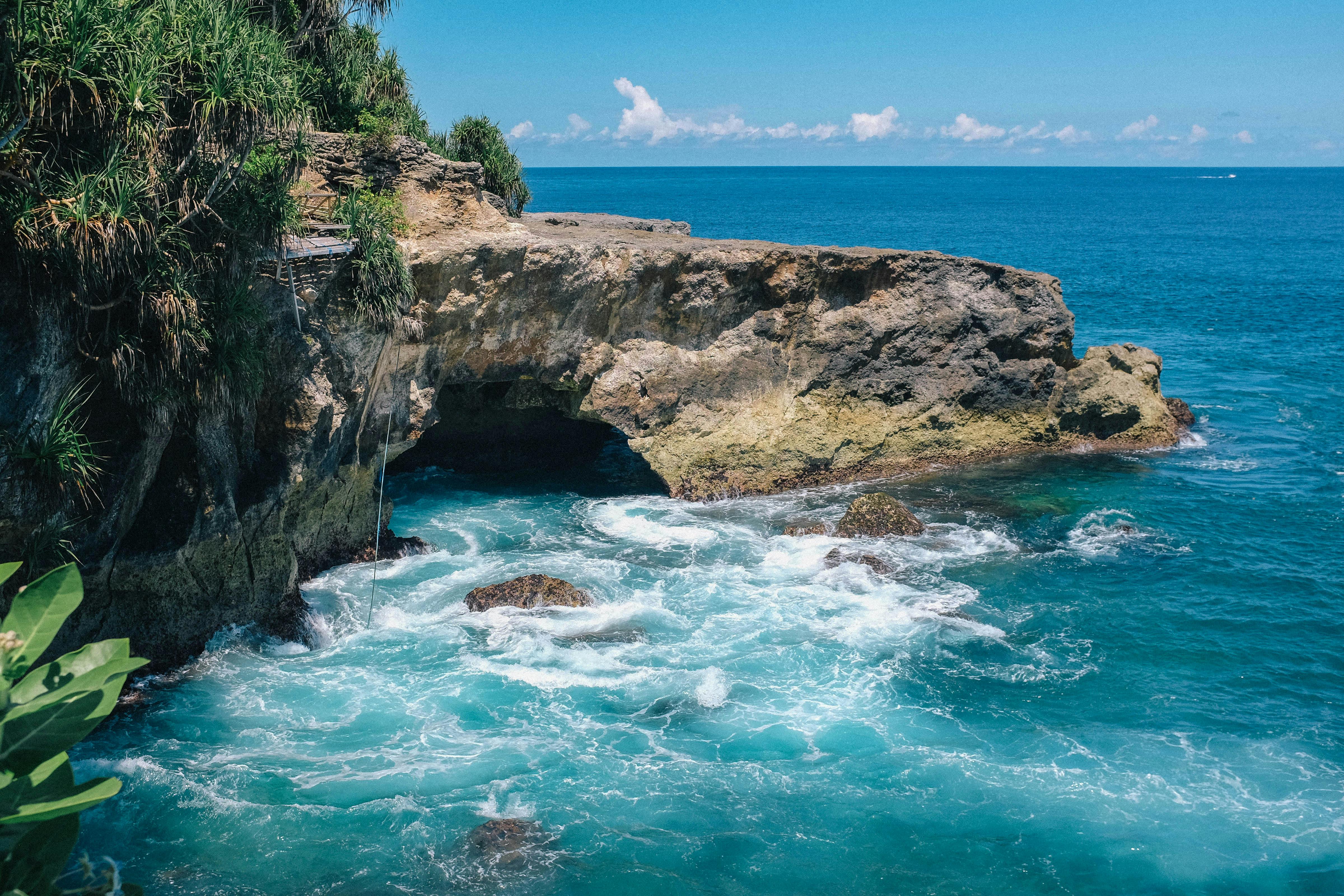 印度尼西亚巴厘岛拥有美丽的岩石海岸线，那里波涛汹涌，绿树成荫，非常适合旅行爱好者