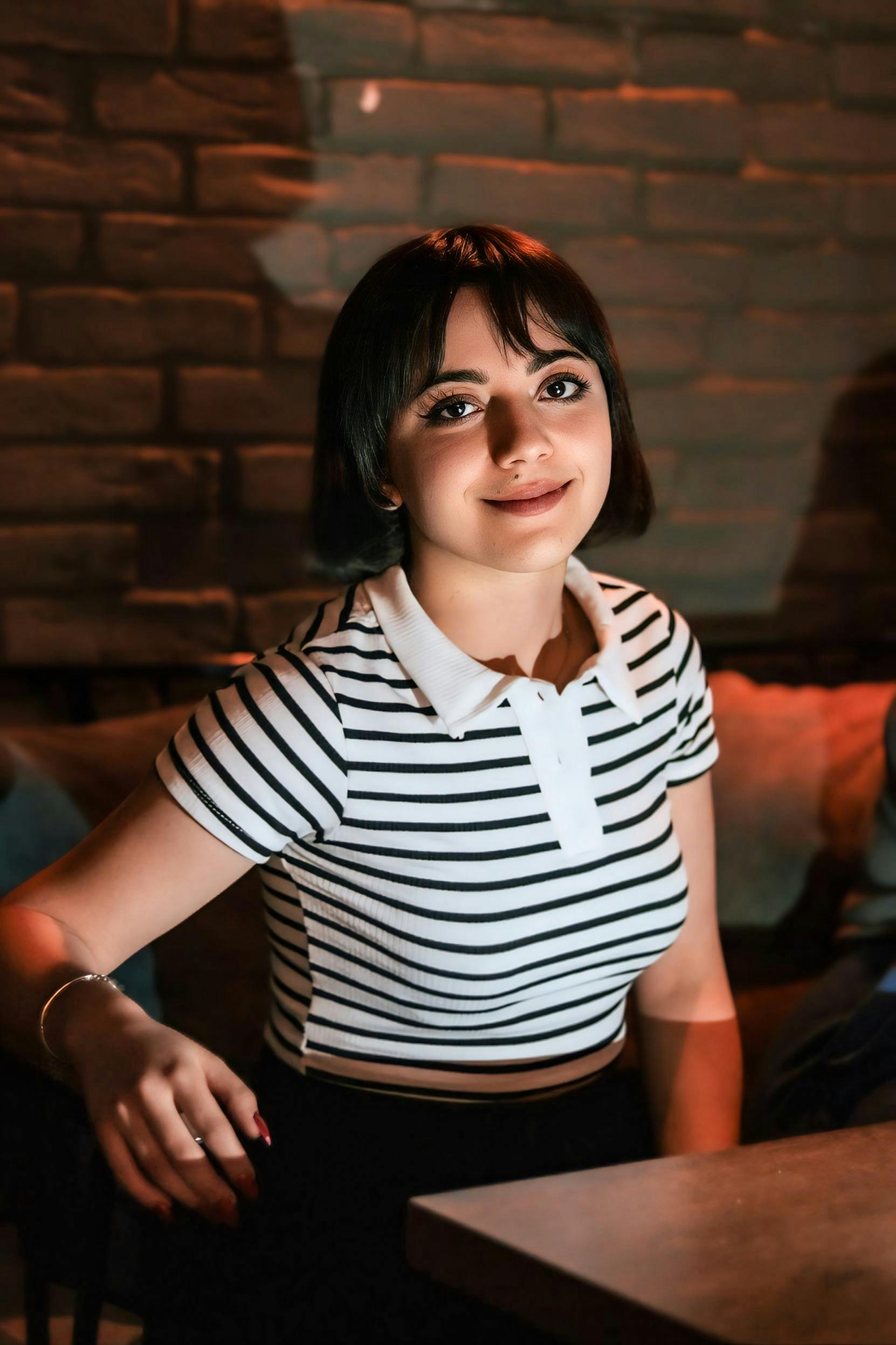 bezplatná Základová fotografie zdarma na téma černé vlasy, cihlová zeď, hezký Základová fotografie