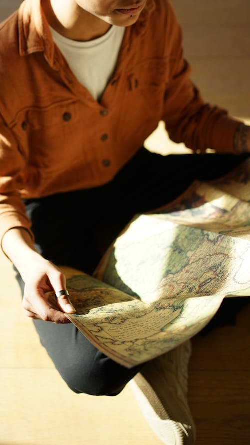 A person sitting on the floor with a map