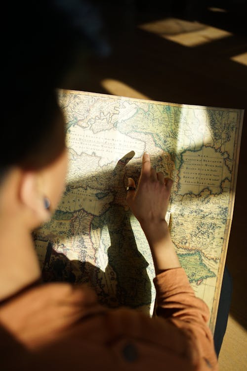 A person is looking at a map with the sun shining on it