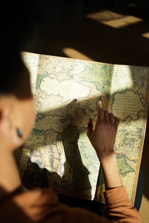 A woman is looking at a map with the sun shining on it