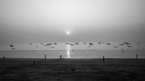 Bunch of boys playing the cricket at beach.