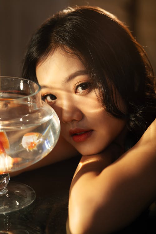 A woman with long hair and a fish bowl