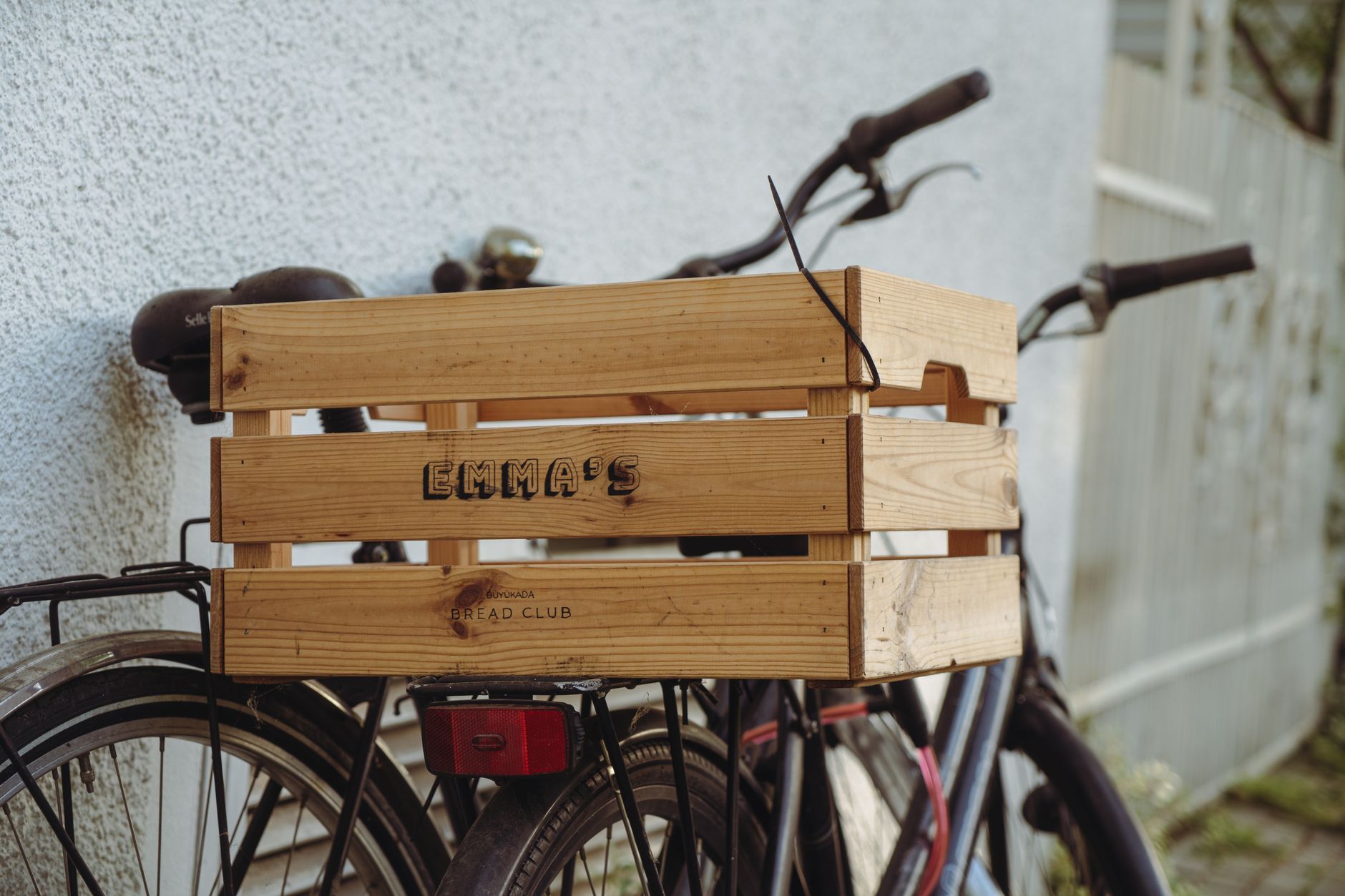 Close-up of a vintage bicycle equipped with a wooden crate parked outdoors, ideal for urban transport themes.