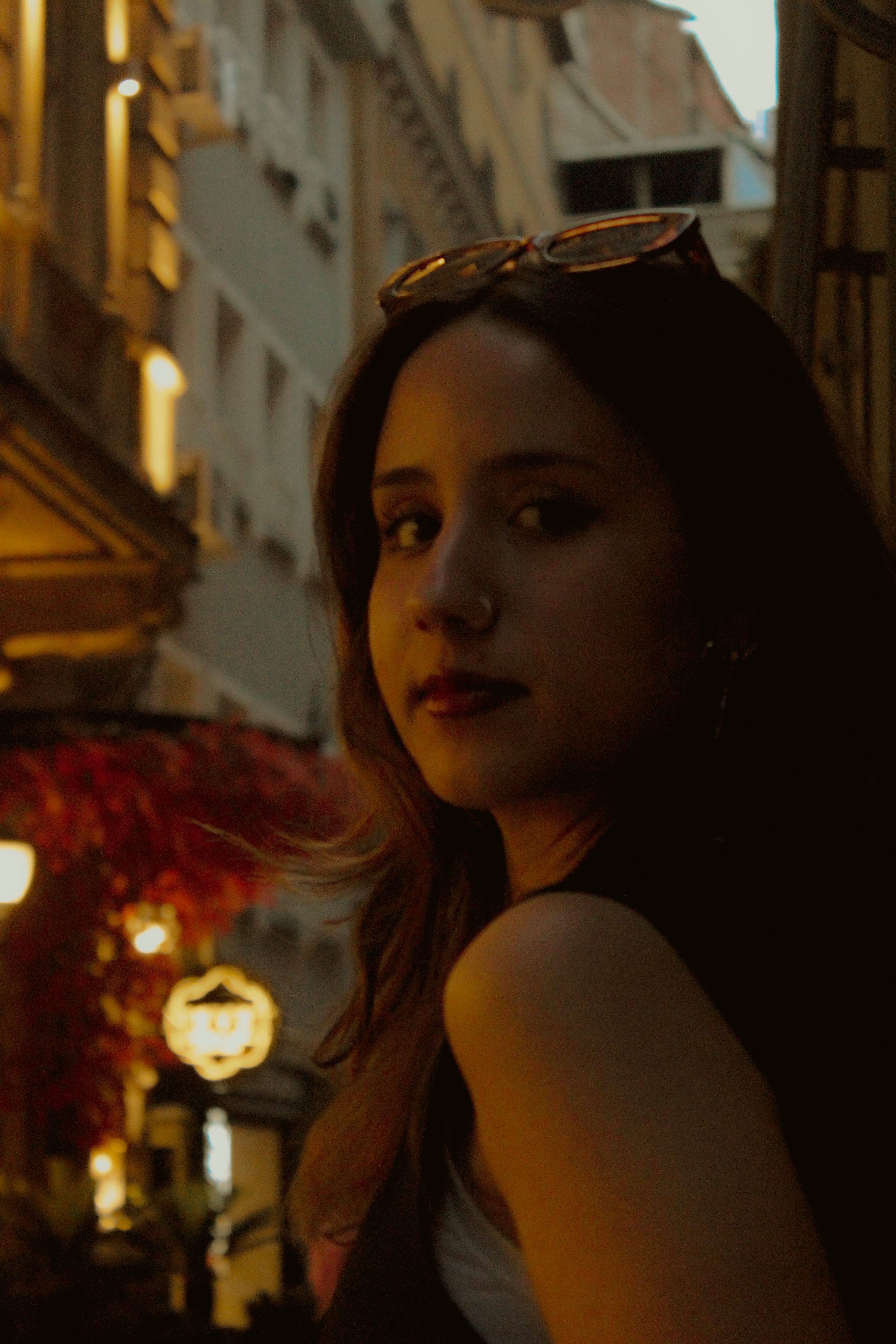 Portrait of a woman in an urban setting at twilight, showcasing evening ambiance.