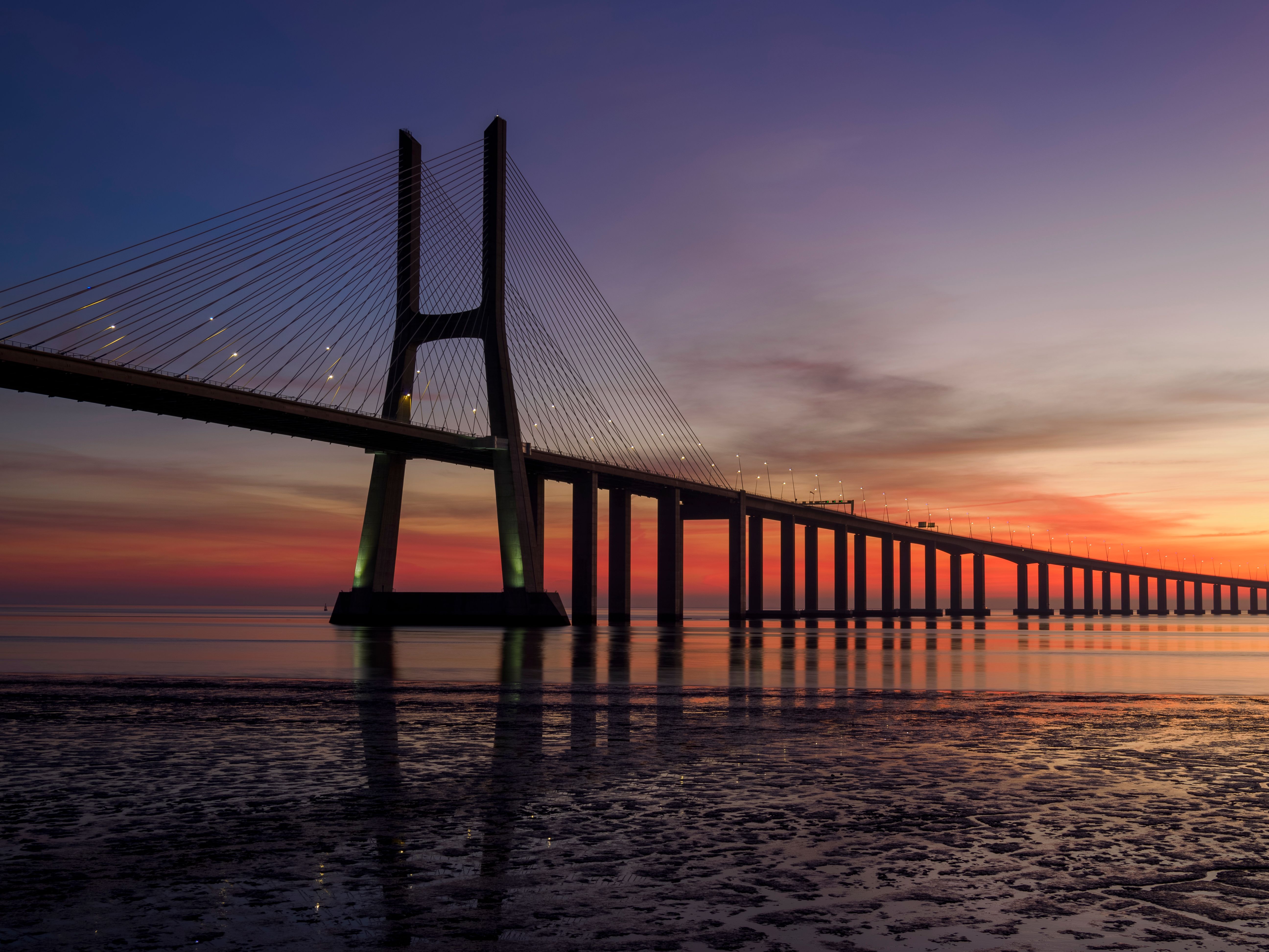 Stunning view of Vasco da Gama Bridge during sunset over the Tagus River in Lisbon, Portugal.