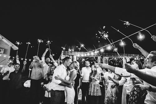 Black and white photo of bride and groom with sparklers