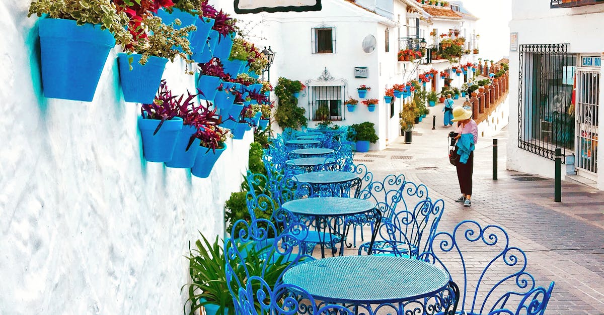 Picturesque outdoor café with vibrant blue chairs in Mijas, showcasing Andalusian charm.