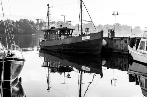 A black and white photo of a boat in a harbor