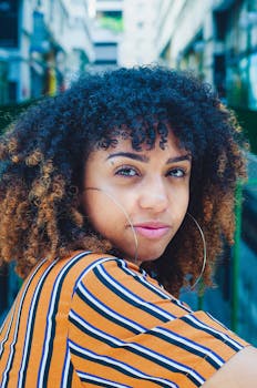 一个卷发年轻女子穿着条纹衬衫，充满活力的户外肖像