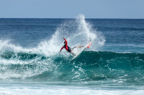 Man Riding Surfboard Under Clear Blue Sky