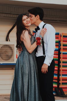 日落时分，一对身着正装的情侣在户外幸福相拥，面带微笑