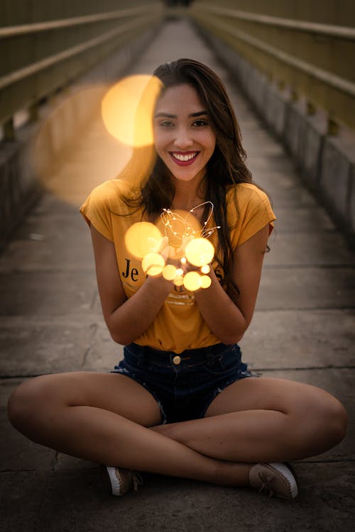 Smiling Woman Sitting Holding String Light