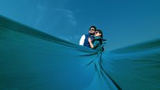 Woman Wearing Blue Maxi Dress Hugging Man Under Clear Blue Sky