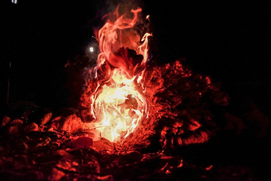 Vivid flames and embers creating warmth and light outdoors at night.
