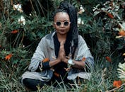 在郁郁葱葱的约翰内斯堡花园里，一个女人正在户外冥想