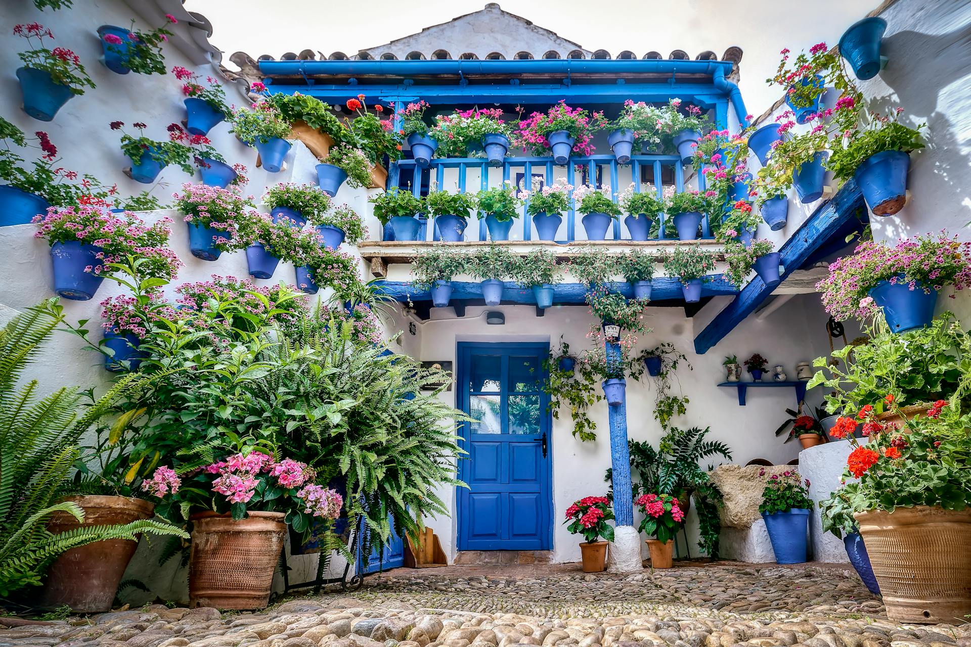 Vibrant patio in Córdoba with colorful flowers and traditional architecture.