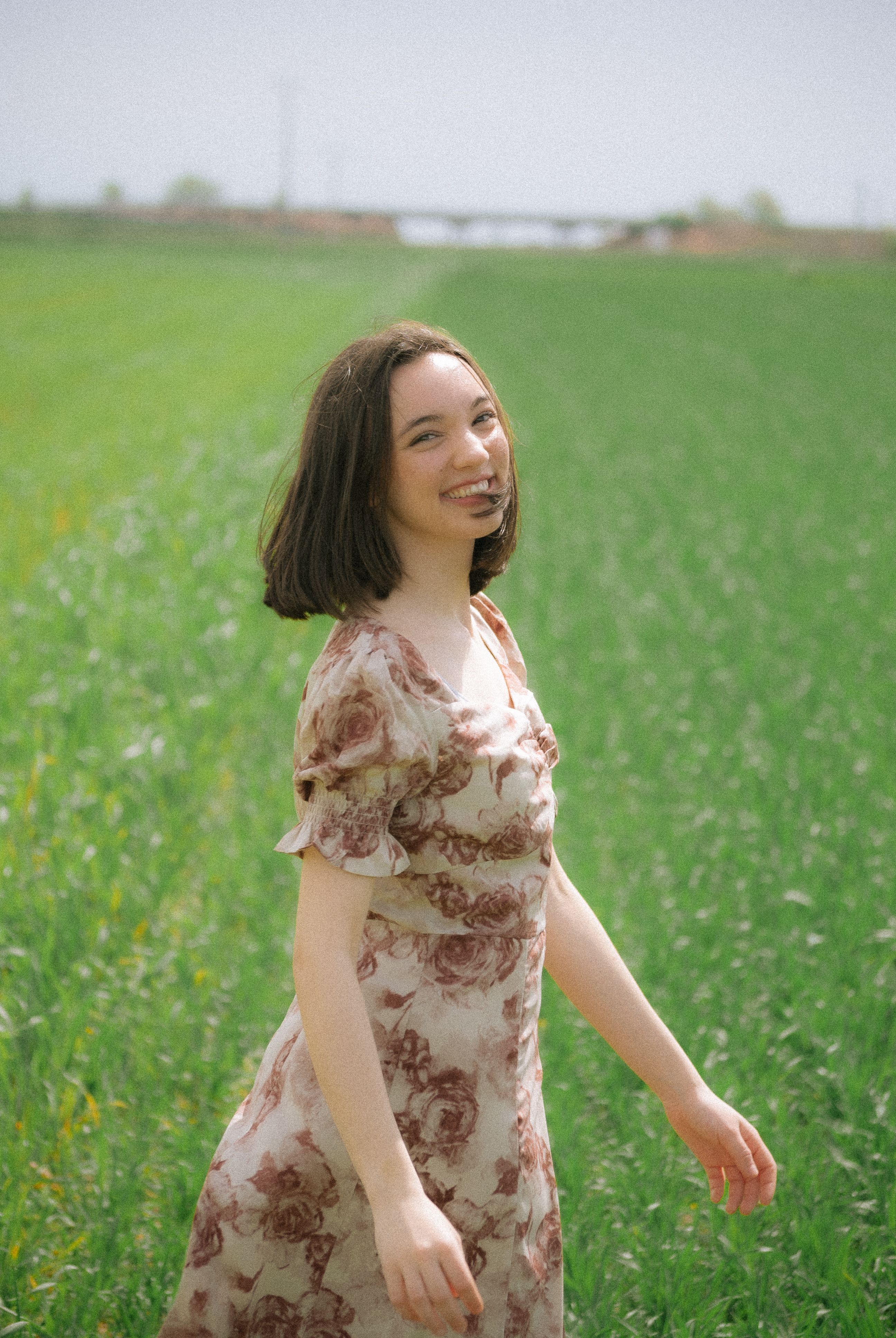 Smiling Model in a Floral Summer Dress in a Meadow · Free Stock Photo