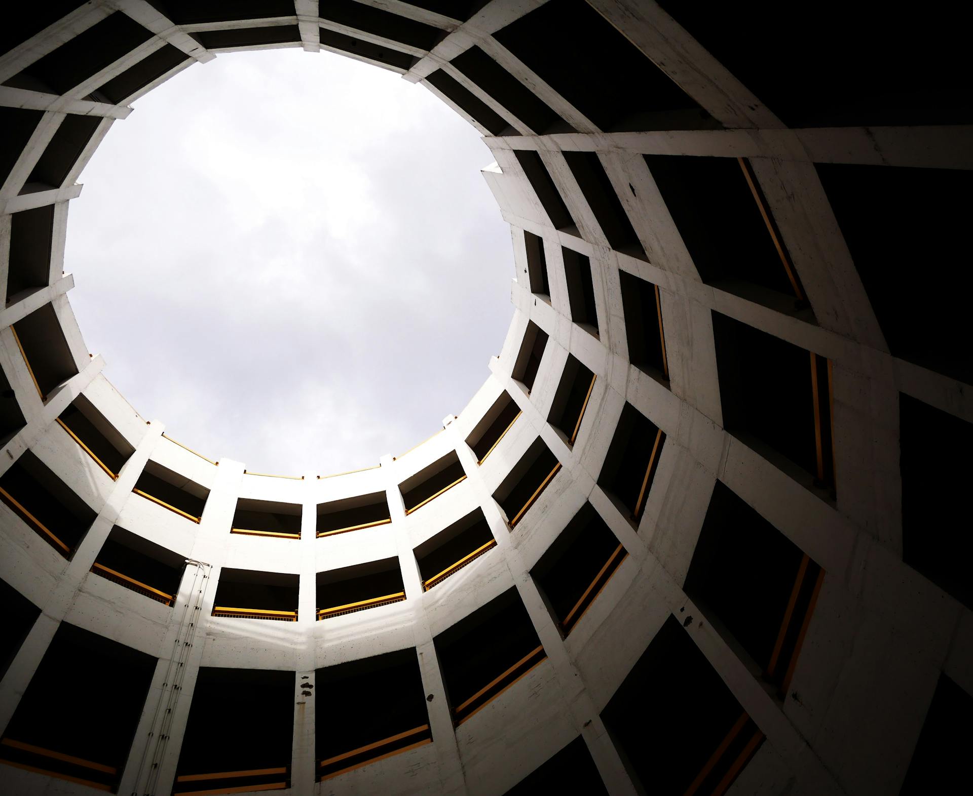 Low angle shot of a circular modern building interior with skylight and geometric design.