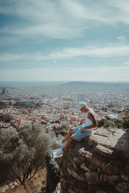 A woman sitting on a rock overlooking the city