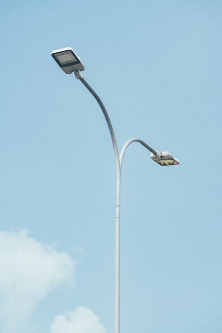 Dual street lamps set against a clear blue sky, showcasing modern urban lighting design.