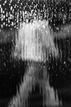 Abstract black and white photo capturing water reflection with blurred lights in Buenos Aires, Argentina.