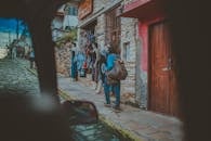 一名女子在古色古香的城市场景中，于精品店旁的鹅卵石街道上购物