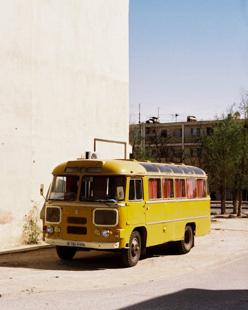 A yellow bus parked in front of a building