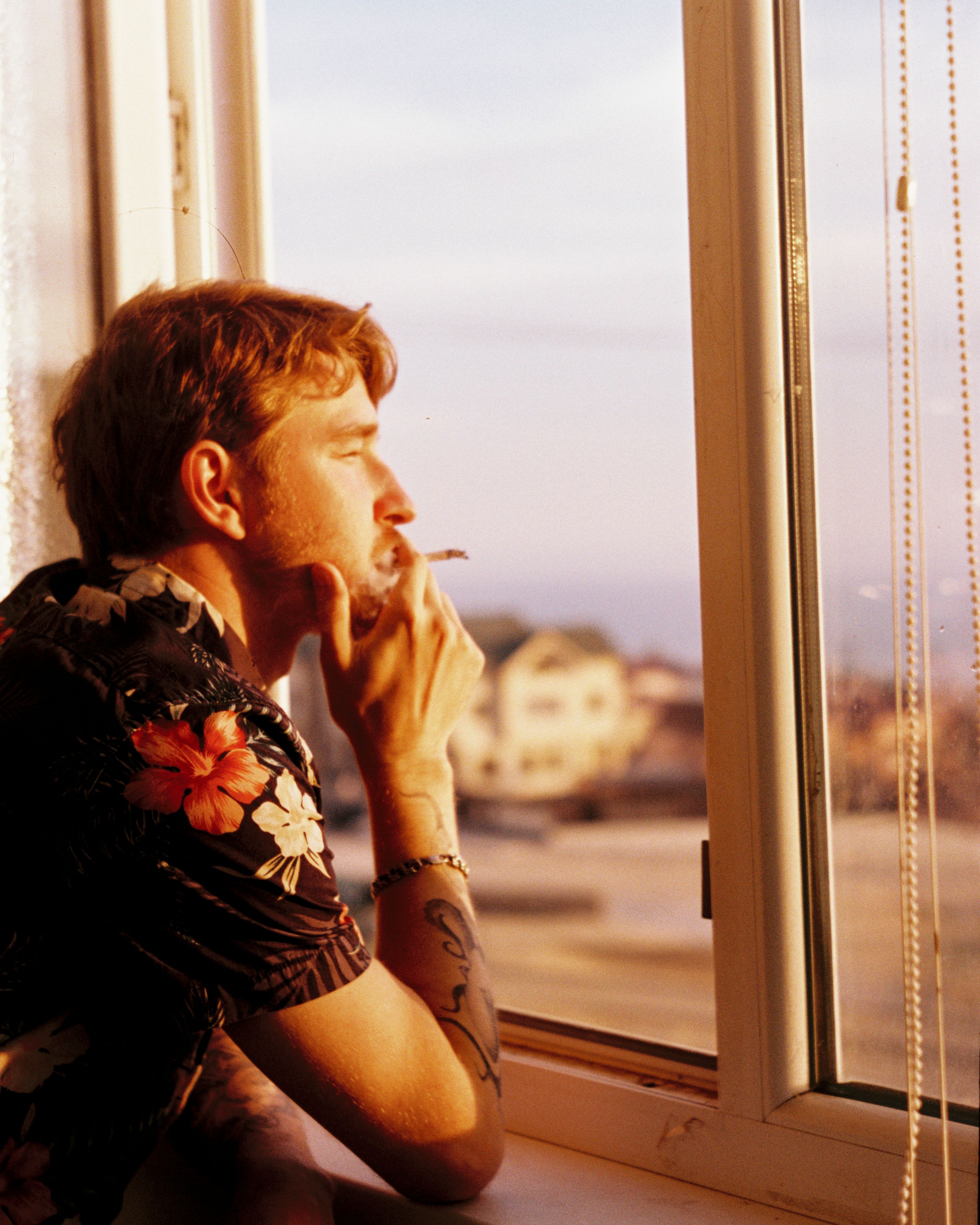 A Man Smoking at a Window · Free Stock Photo