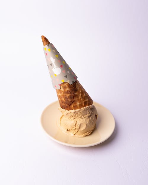 A cone with sprinkles on top of a plate