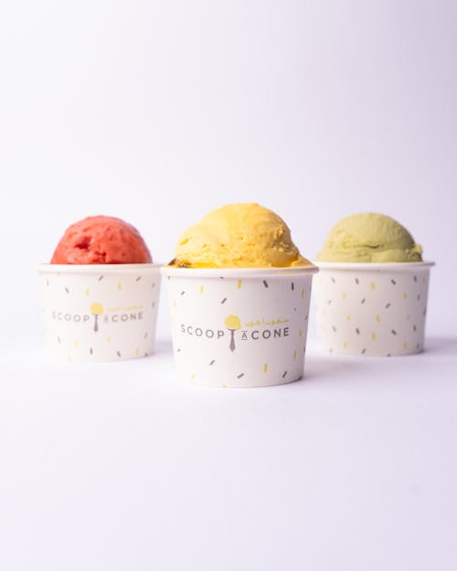 Three different flavors of ice cream in paper cups