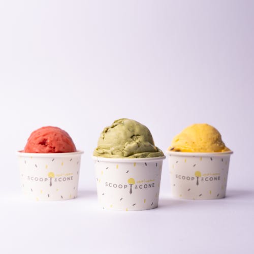 Three different flavors of ice cream in paper cups