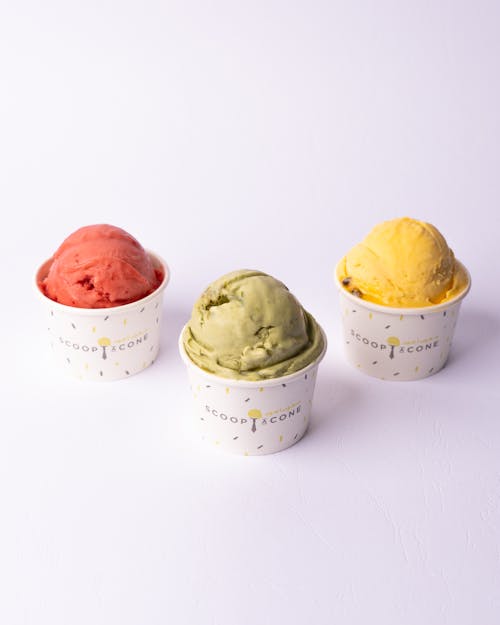 Three ice cream cups with different colors and flavors