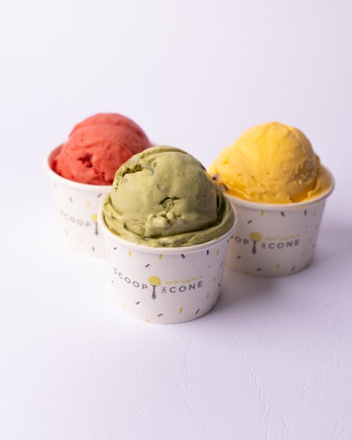 Three different colored ice cream in cups