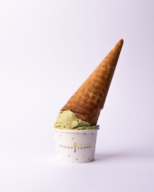 A cone of ice cream with a green leaf on top