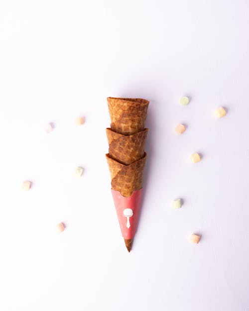 A cone with sprinkles and confetti on top